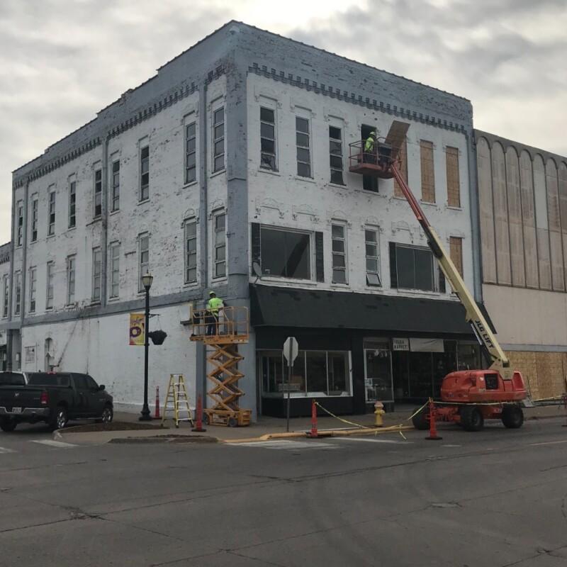 Before photo featuring a neglected historic building with blue paint and construction equipment