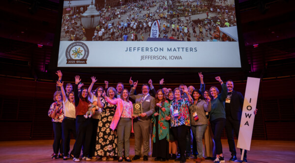 Jefferson Matters team holding their 2025 GAMSA plaque while posing for a celebratory photo, with the 2026 GAMSA visible in the lower right corner.