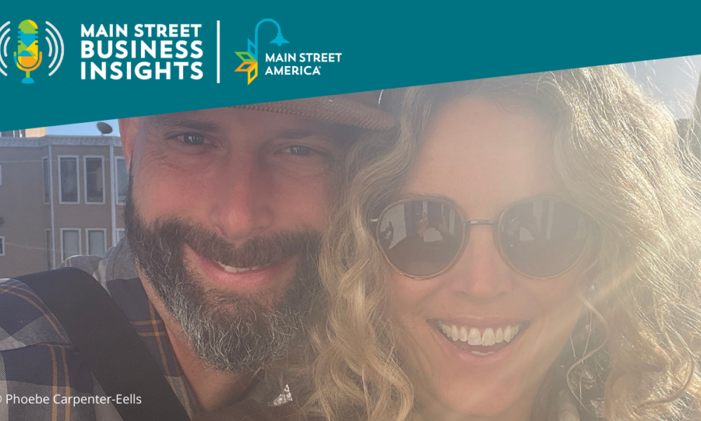 Man with beard and baseball cap smiles with woman with curly blonde hair and aviator sunglasses.