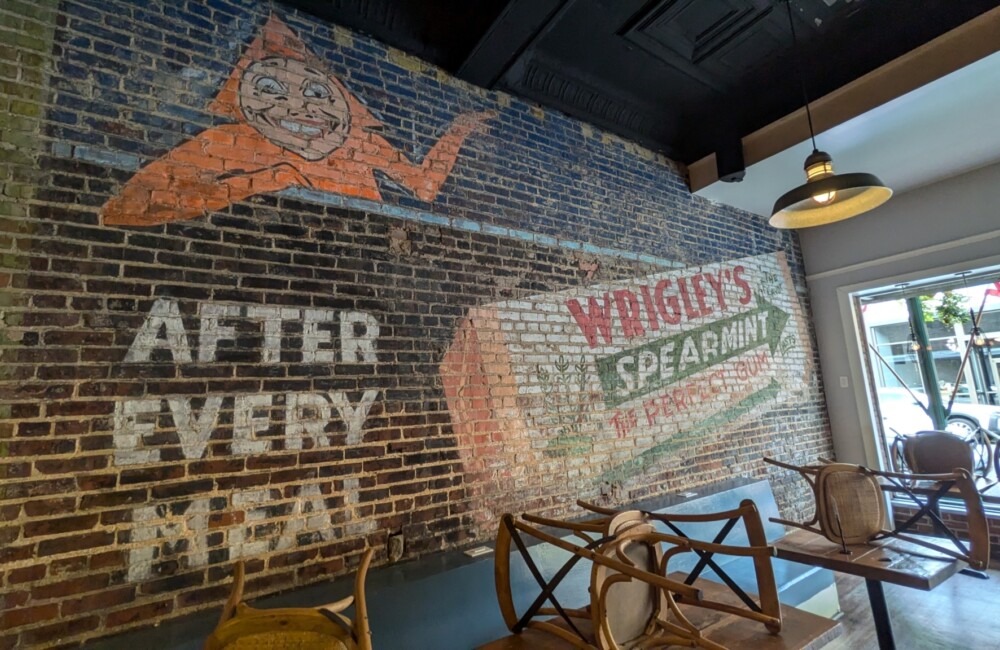 Interior brick wall with old-fashioned advertisement for Wrigley's spearmint gum painted on wall.