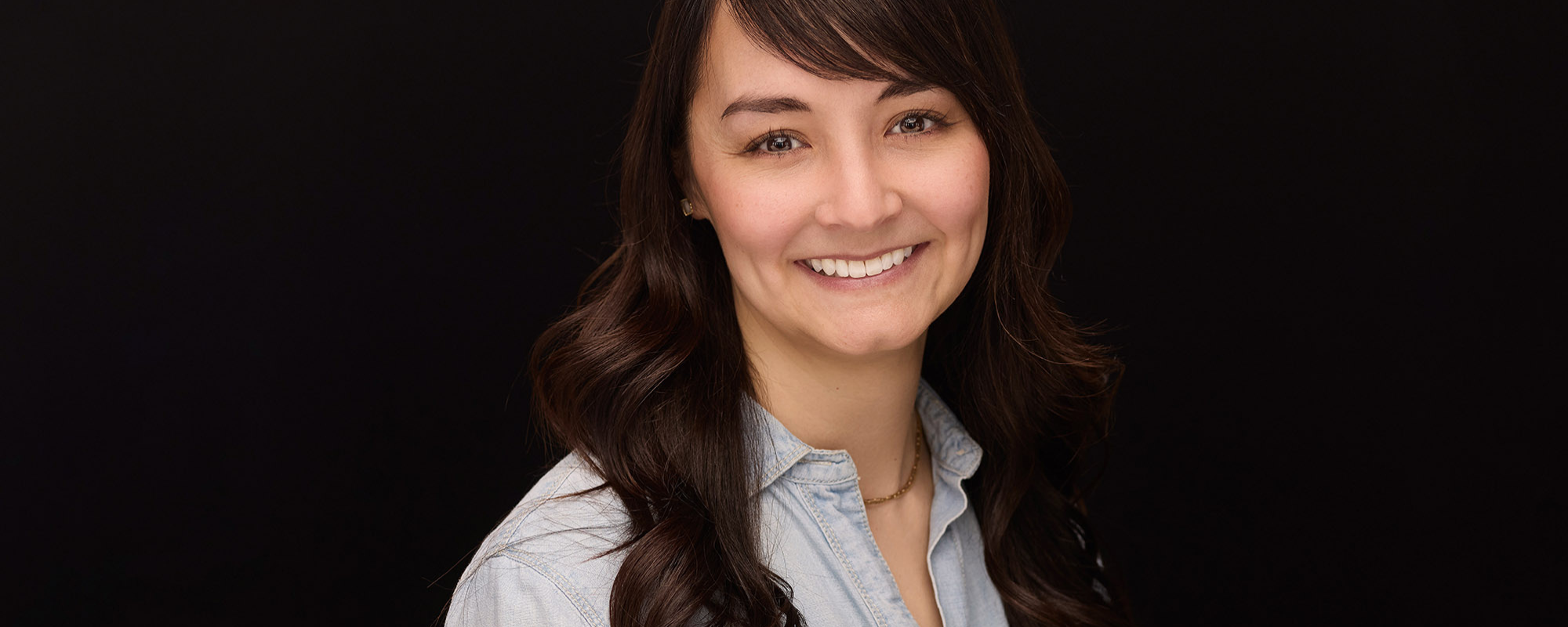 Headshot of a smiling young woman with brown hair.