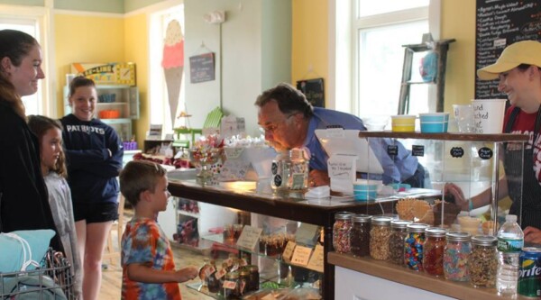 A group of kids browsing ice cream flavors in an ice cream shop