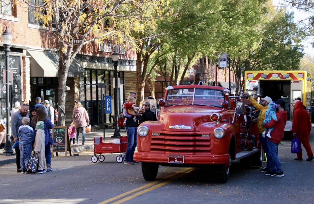 Kids in costume explore police and fire department vehicles