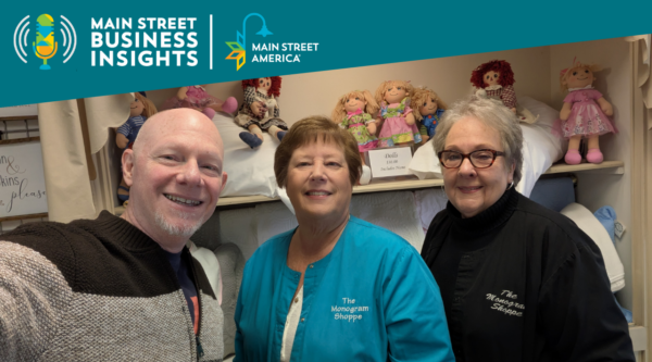 Man posing with two women in front of store display