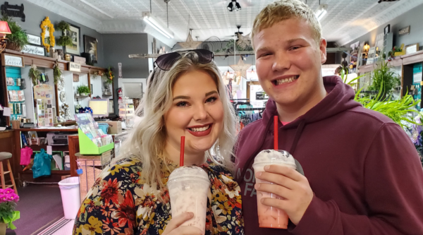 A man and a woman pose for a photo in a small business