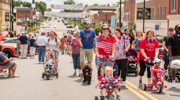 Image of groups of families in patriotic colors walking down main road in Wytheville, VA.