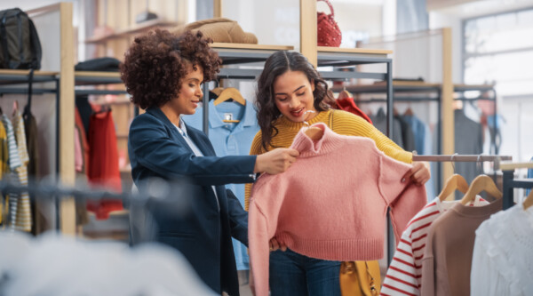 Two women shopping for clothing in a retail store