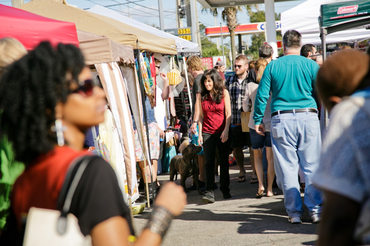 People check out vendor booths at an outdoor event.