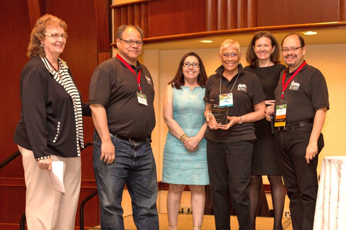 A small group of people accept an award.