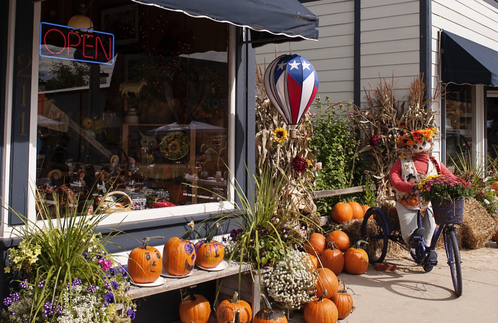 Bright orange pumpkins placed in front of retail stores.