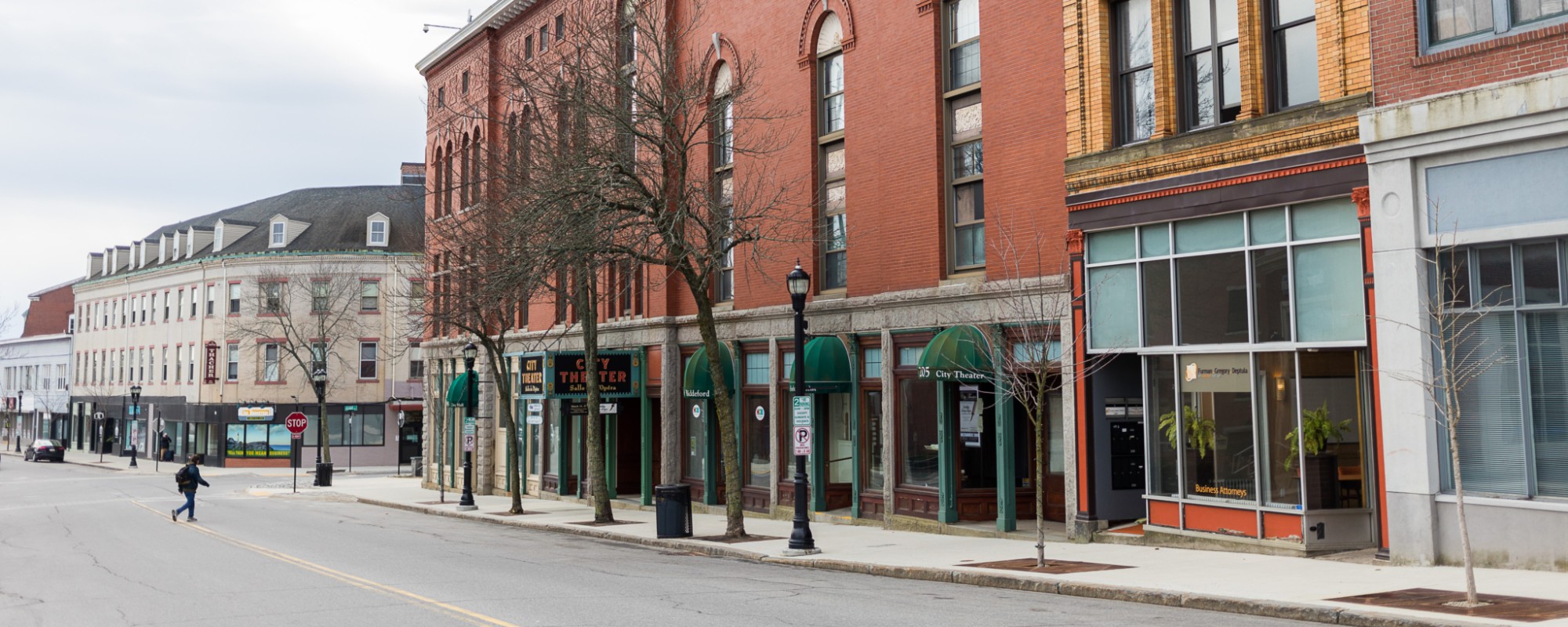 Beautifully maintained historic, multi-story brick buildings line a wide downtown roadway.