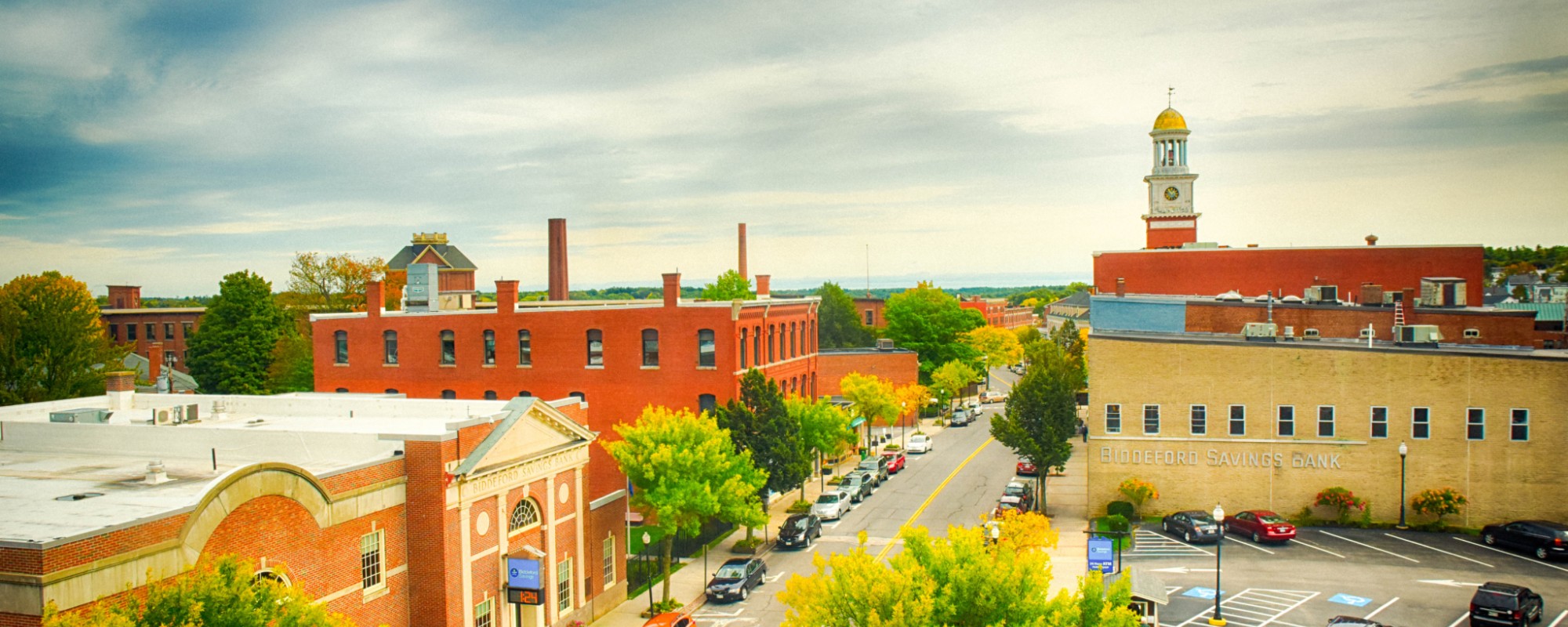 Skyline of a historic New England downtown from a rooftop vantage point, with brick buildings and the spire of a church visible.