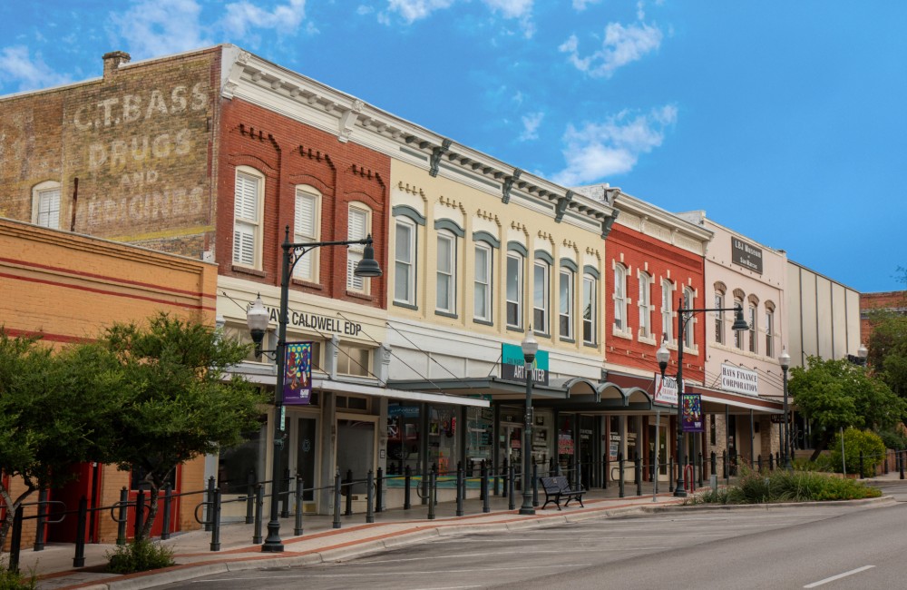 A row of old, colorful buildings line an empty street.