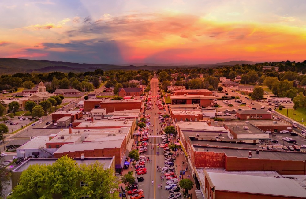 An aerial view of a main street with buildings on either side during a sunset.