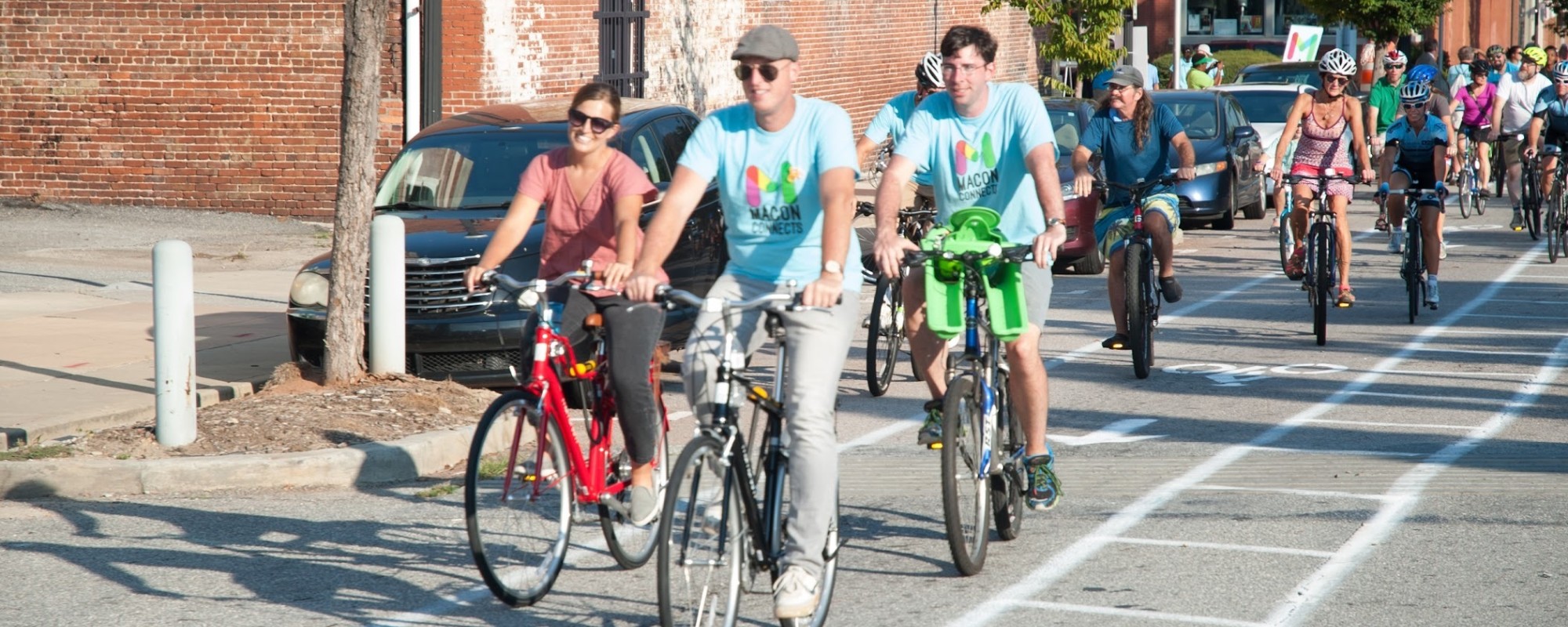 A large group of cyclists traveling down a bike lane.