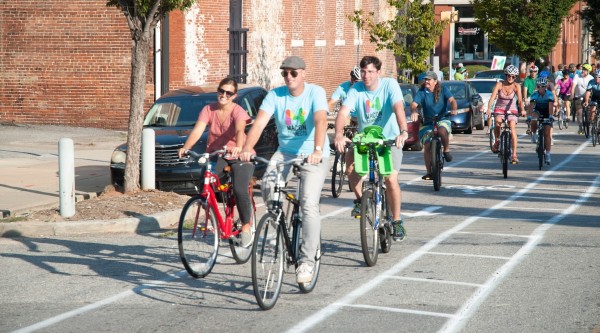 A large group of cyclists traveling down a bike lane.