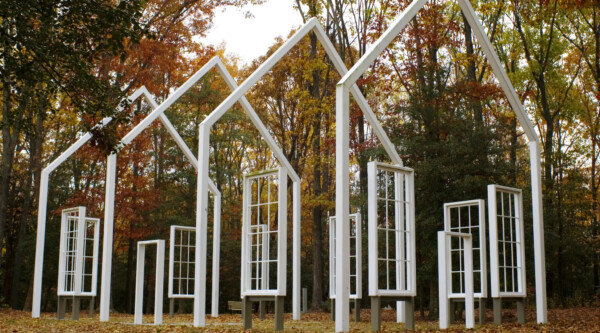 White building frame in a forest clearing.