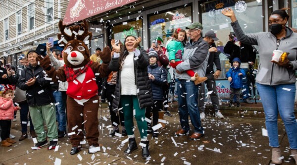 People cheer as confetti falls from above.
