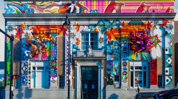 Historic bank building with a colorful art installation on the façade.