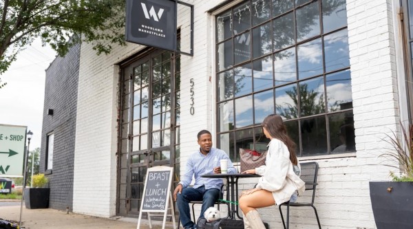 Two people sit at bistro table.