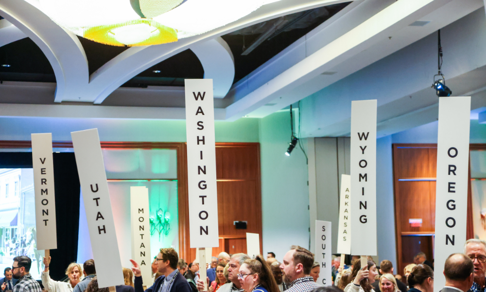 Attendees at the 2023 Main Street Now conference holding up state signs