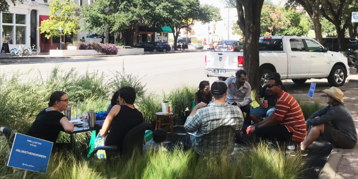 People sitting at tables in a parklet