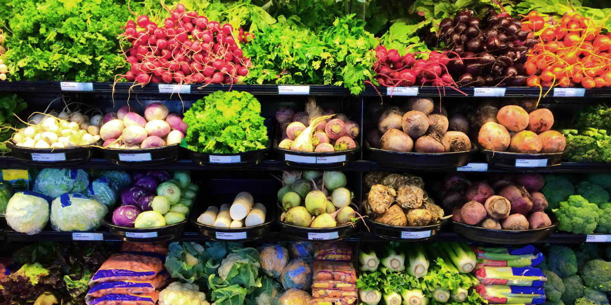Shelves of cold produce in a small grocery store