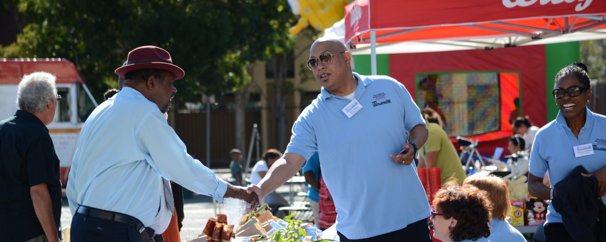 Two men shake hands at a community event