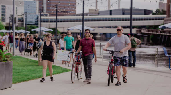 People walking with bicycles in a downtown area
