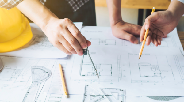 People pointing at details on a construction plan