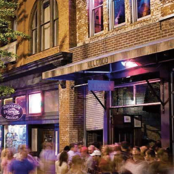 People walking in a downtown streetscape at night.