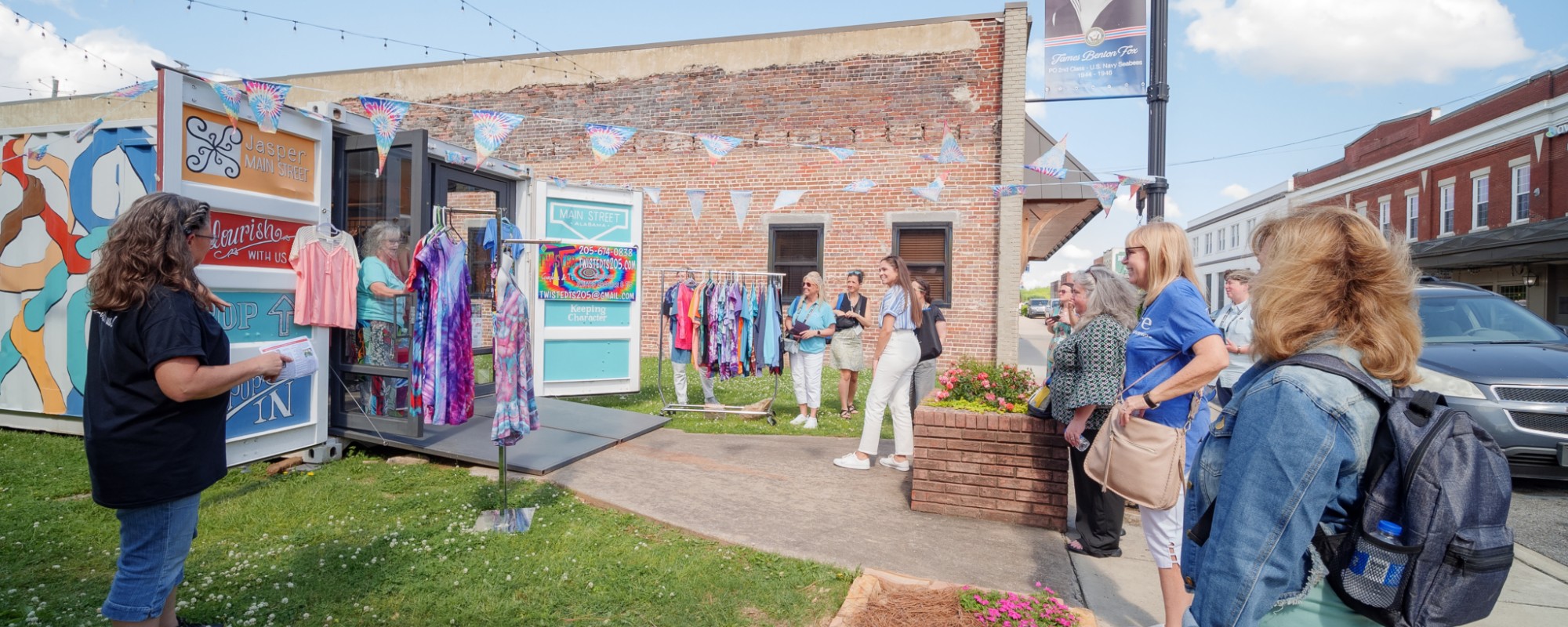 A group of people check out a retail store operating from a storage container.