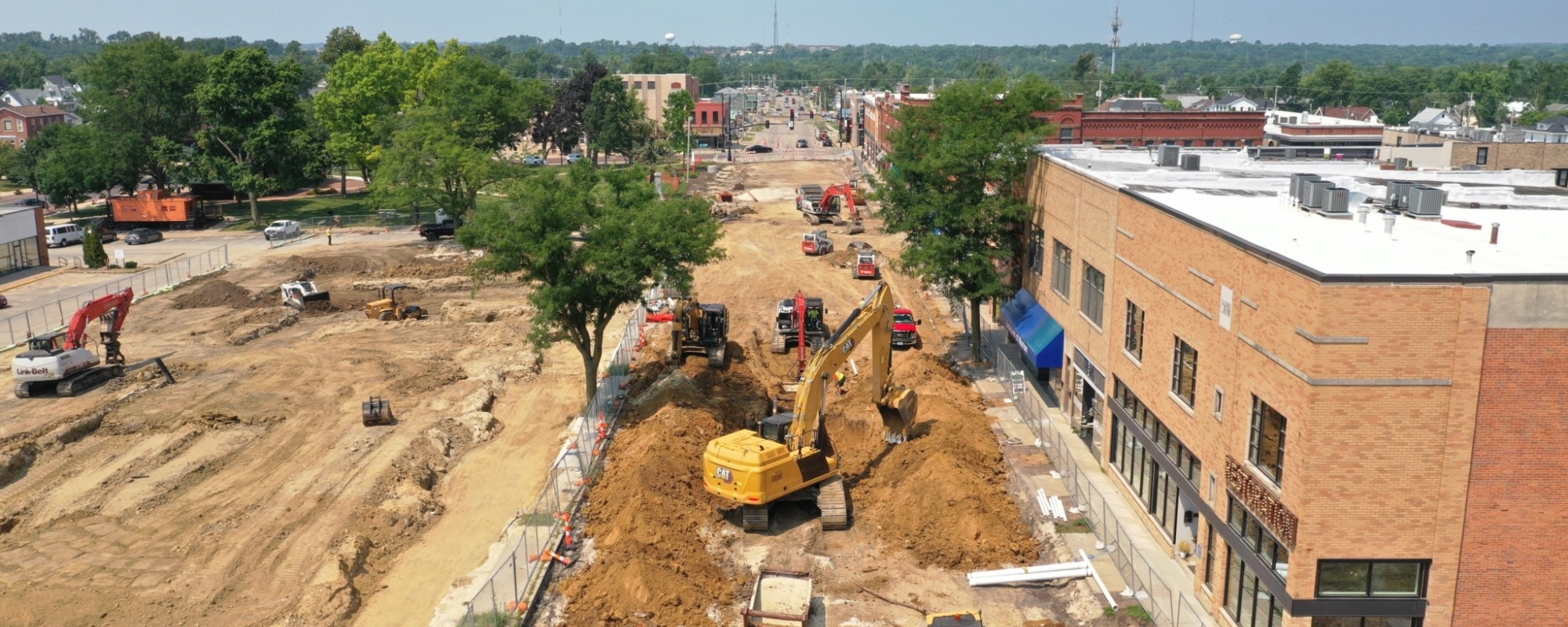 A streetscape improvement project in progress with heavy machinery working on a downtown street