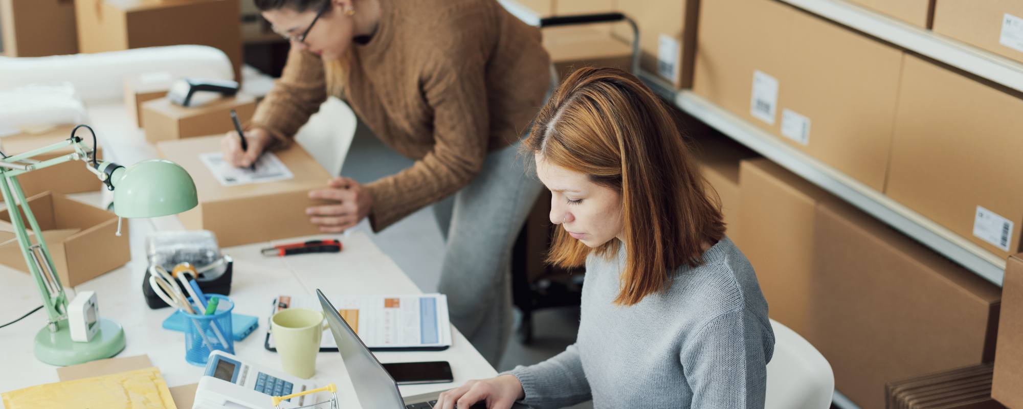 Two women process inventory and packages for a small business