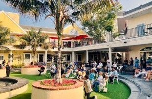People sitting in chairs in an outdoor courtyard space