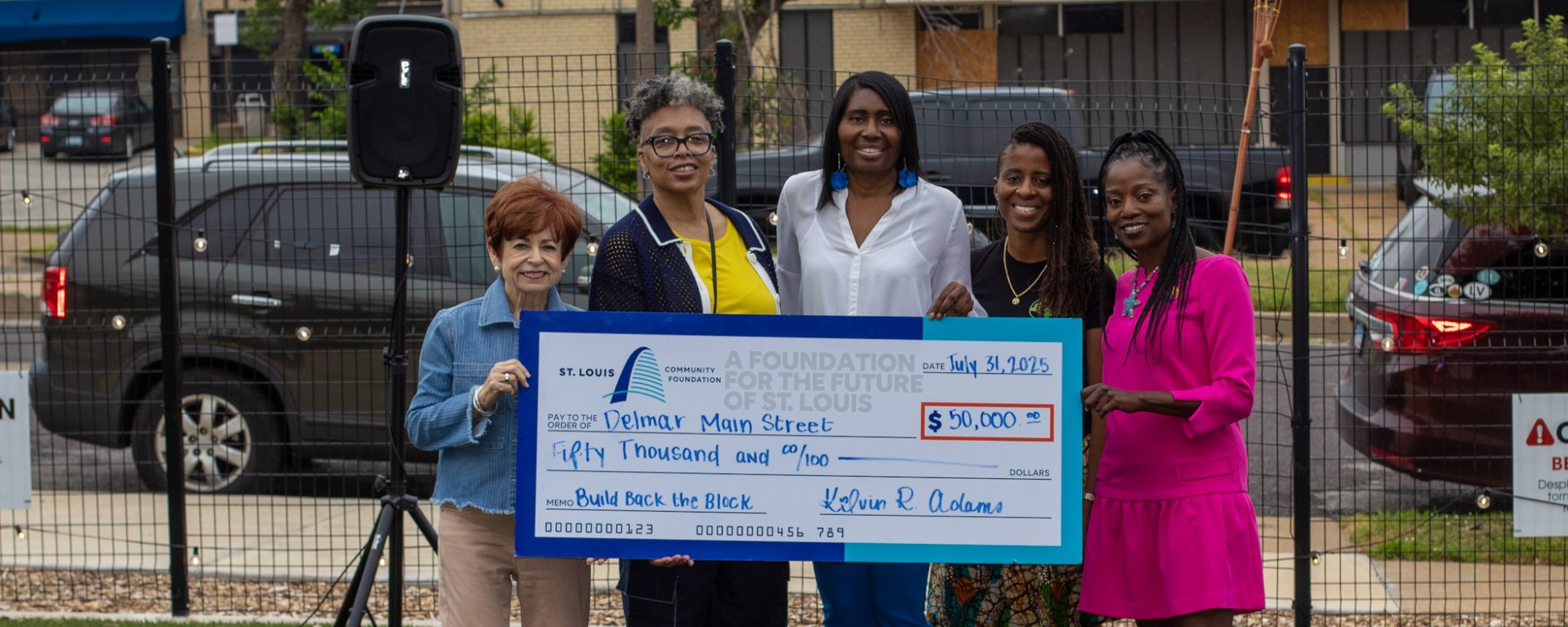 A group of women hold a ceremonial check.