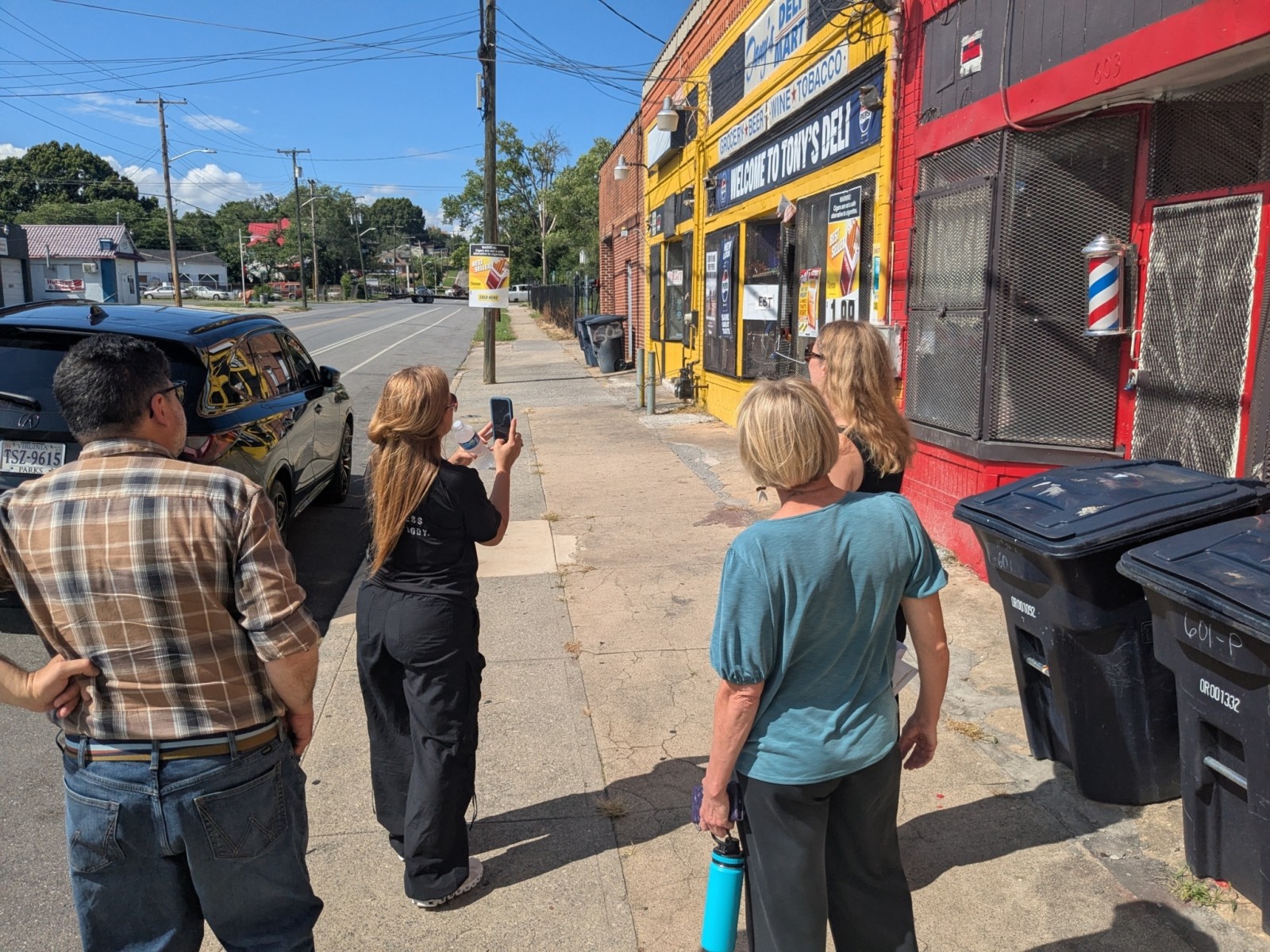 Gustavo Ustariz, Wendy Otero, and Bethany Rogers walk down a street in Roanoke, VA