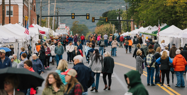 Crowds of people browse at vendor stalls during an outdoor event