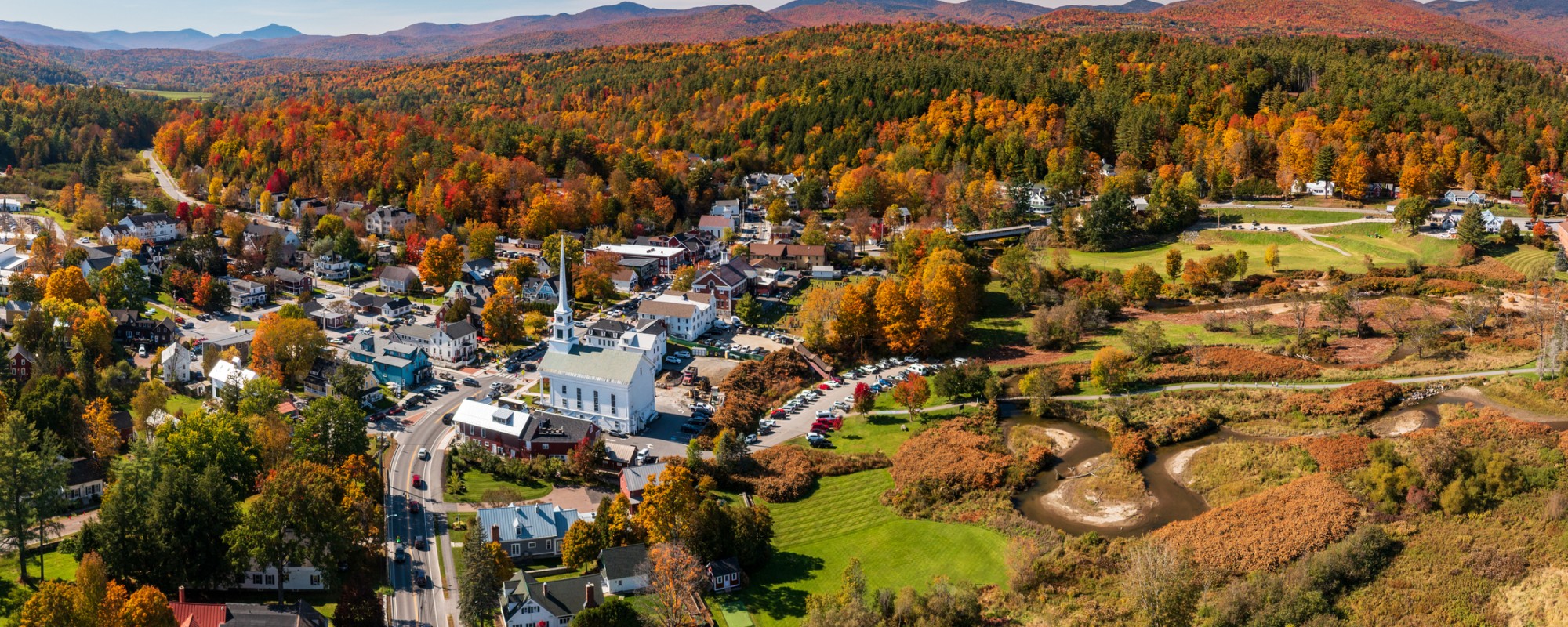 Vibrant fall colors across a hilly landscape dotted with historic buildings