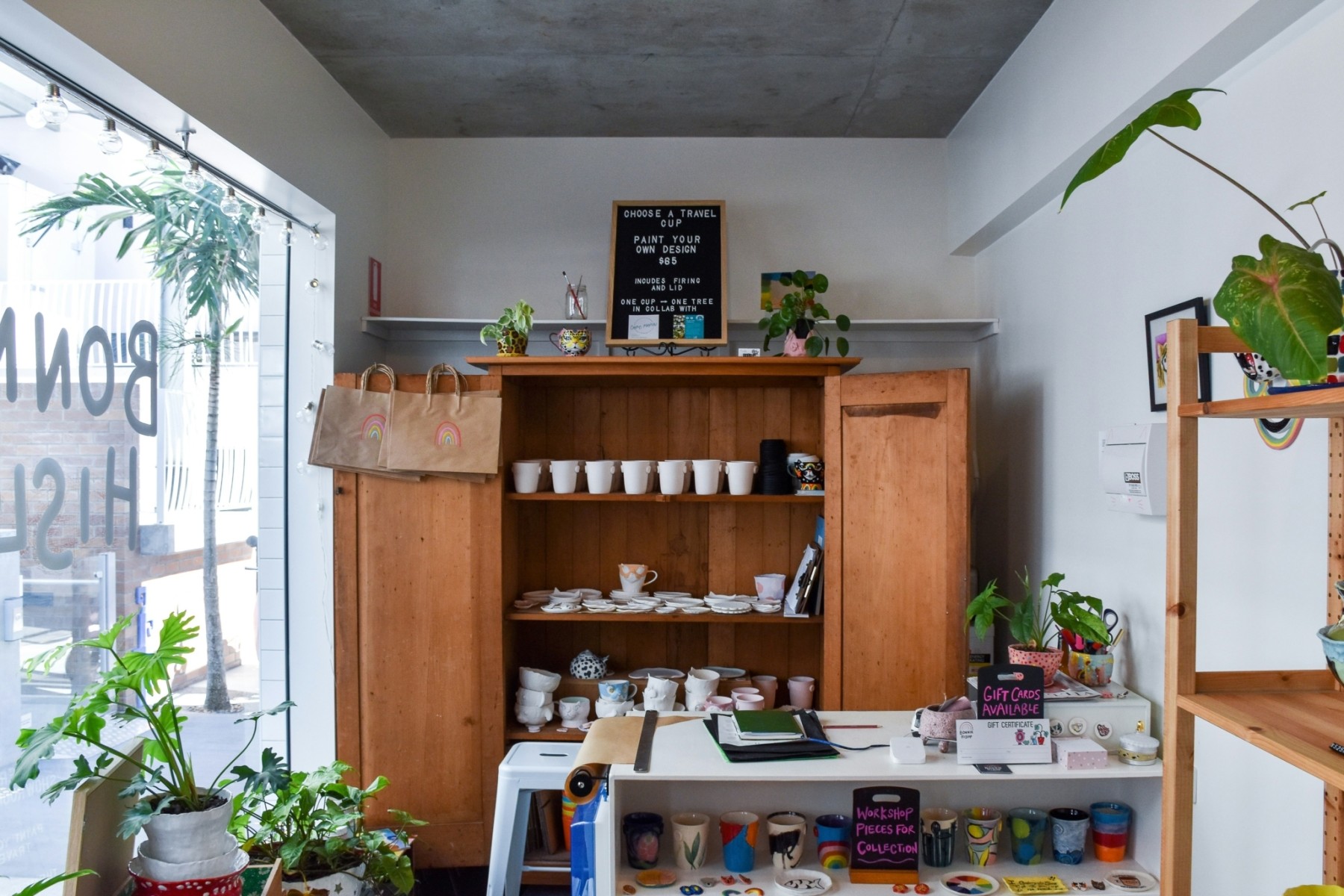 Interior of a small retail store with wooden shelves displaying items for sale