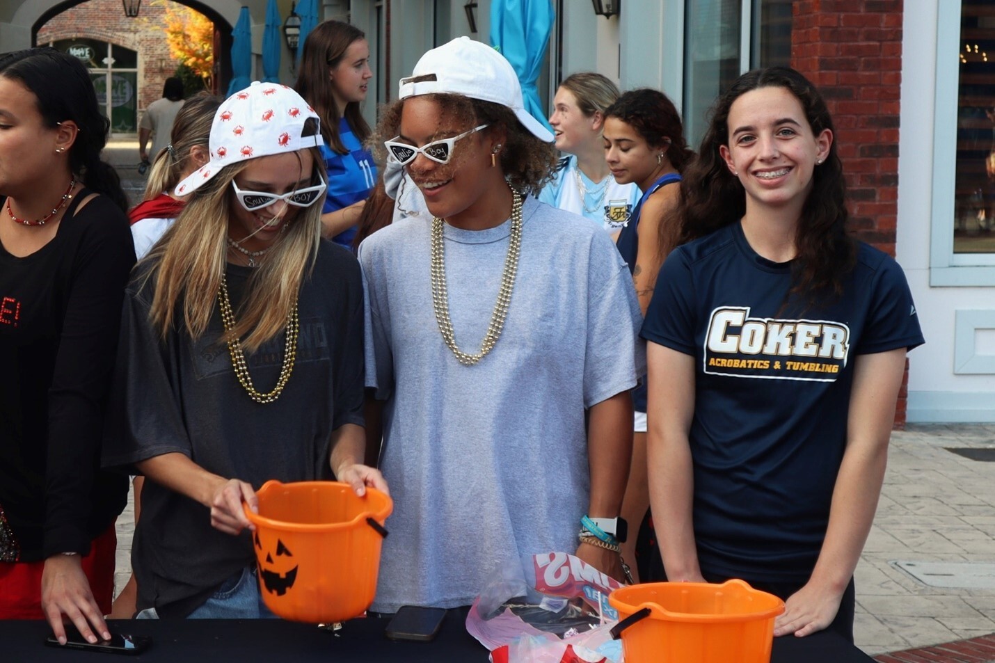 Students wearing Coker University shirts look through buckets of halloween candy