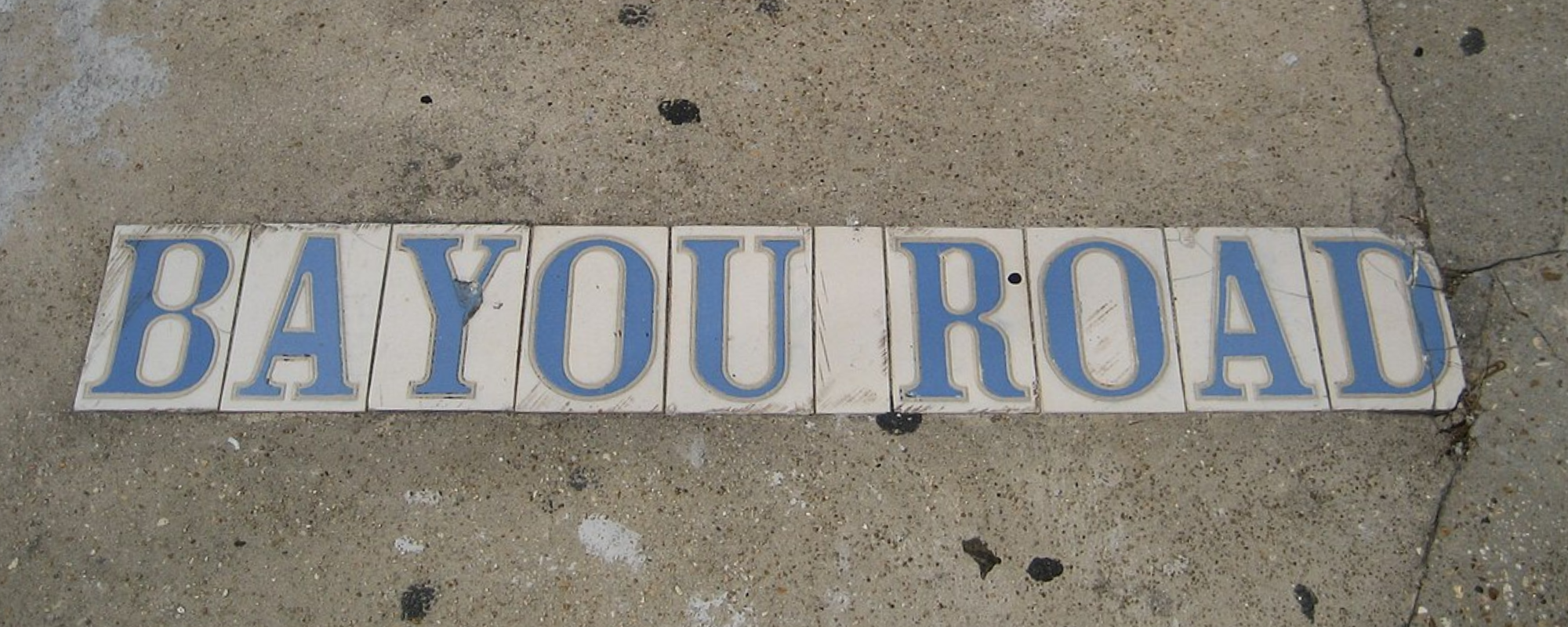Tiles reading "Bayou Road" inlaid on a sidewalk