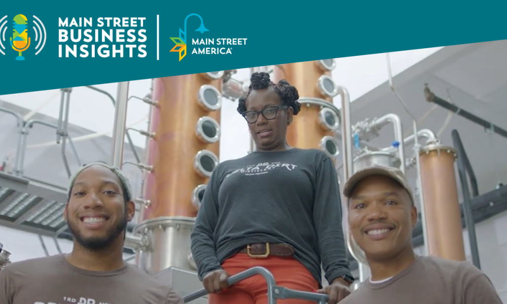Three family members, a mother, father, and son, stand in front of distilling equipment.