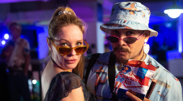 Two people pose wearing 90s-inspired clothing