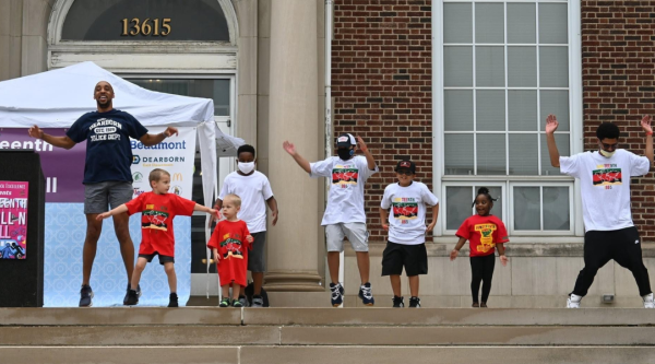 Children and adults jump up and down on the steps of Dearborn city hall