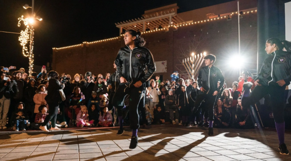 Children dance traditional Indian choreography in front of a crowd at a downtown event