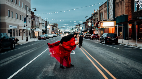 A man sweeping a woman into a romantic kiss on a Main Street