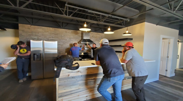Developers working in a half-finished residential kitchen and dining area