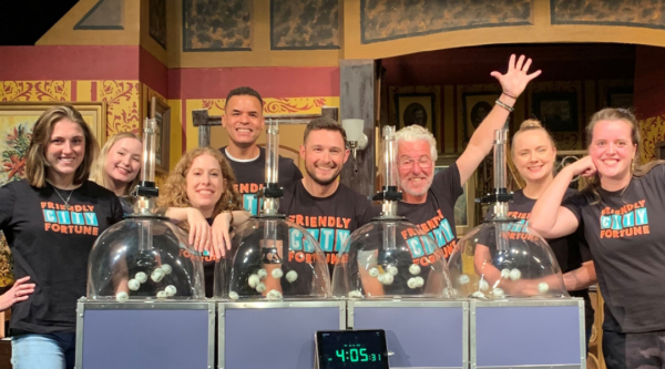 Raffle staff at Friendly City Fortune pose behind the raffle drawing machines