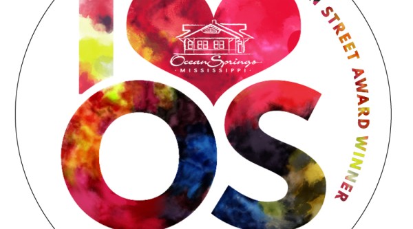 Black circle with letters IOS and words, "Great American Main Street Award Winner: Chamber of Commerce Main Street Tourism Bureau Ocean Springs, Mississippi"